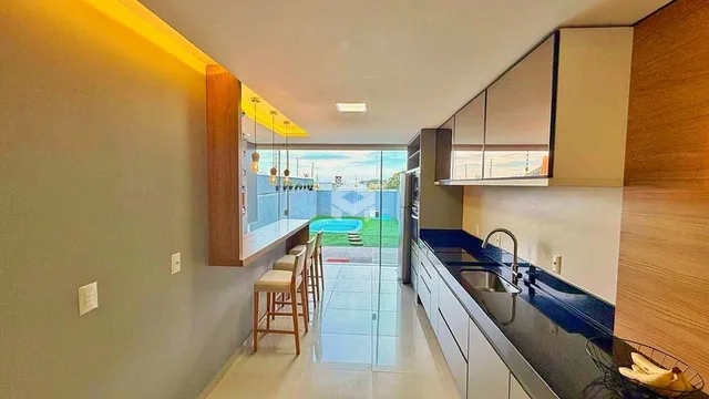 Um ambiente de estar com vista para uma área externa com piscina.