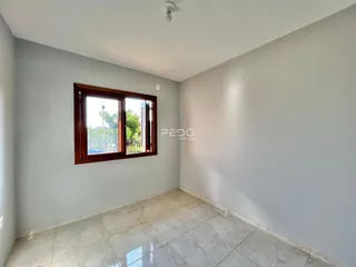 Uma sala com paredes cinzas e piso de cerâmica clara.
