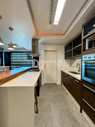 Interior de uma cozinha com armários de madeira e bancada clara.