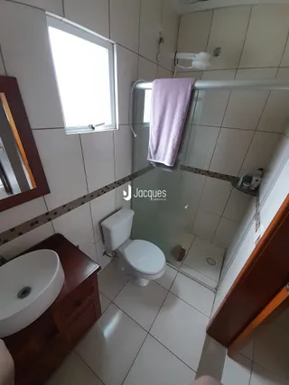 Foto de um banheiro com piso de cerâmica e box de vidro.