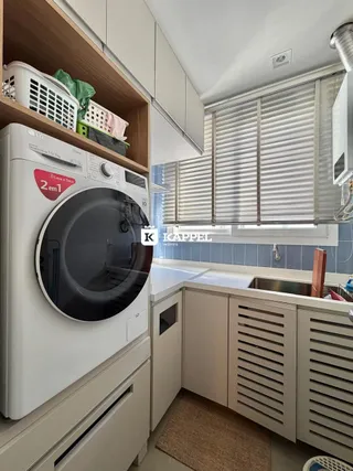 Cozinha com armários brancos e máquina de lavar roupa instalada.