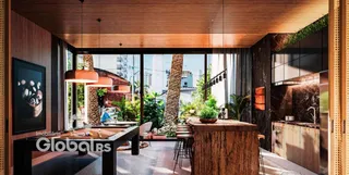 Sala de estar com piso de madeira e portas de vidro que dão para o exterior.
