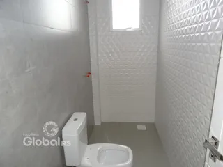 Foto de um banheiro com revestimento de azulejos brancos.
