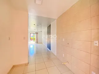 Corredor interno de uma residência com piso de cerâmica claro.