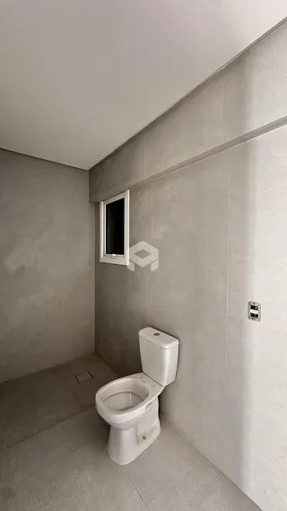 Foto de um banheiro interno com piso claro e azulejos brancos.