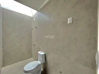 Foto de um banheiro interno com revestimento de cerâmica e vaso sanitário branco.