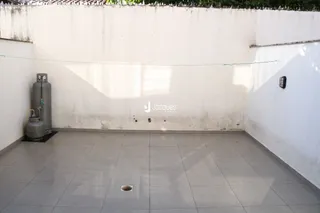 Imagem de uma sala com paredes brancas e piso de cerâmica.
