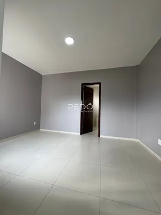 Ambiente interno com piso de cerâmica e paredes cinzas.