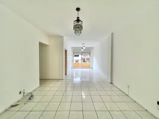 Corredor longo com piso de cerâmica claro e paredes brancas.
