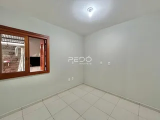 Vista interna de um cômodo com piso de cerâmica branca.