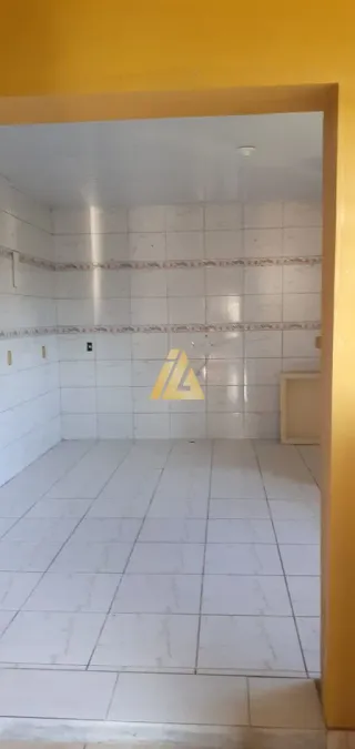Interior de um cômodo com piso e paredes brancas de azulejo.