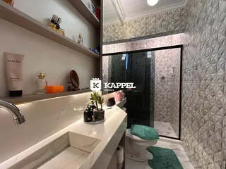 Banheiro com bancada de mármore e espelho em um imóvel.