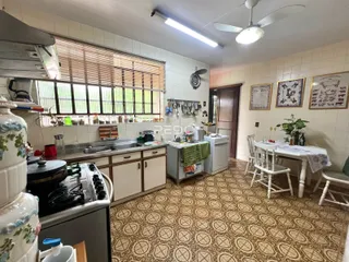 Foto de uma cozinha com armários e uma mesa de jantar em um imóvel no Brasil.
