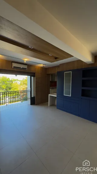 Sala de estar com painéis de madeira e acesso a uma varanda externa.