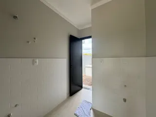 Hall de entrada com paredes brancas e piso de cerâmica.