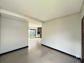 Corredor interno com piso claro e paredes brancas.