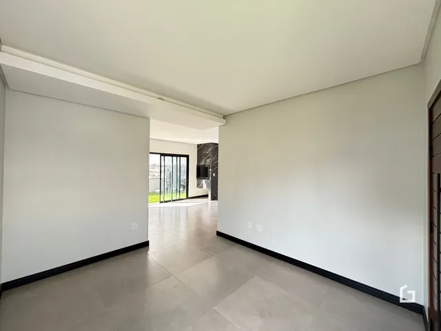 Corredor interno com piso claro e paredes brancas.