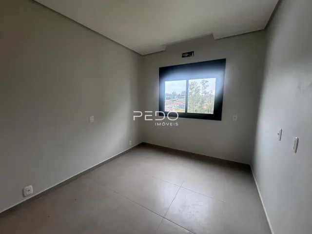 Vista interna de um ambiente com paredes brancas e piso de cerâmica.