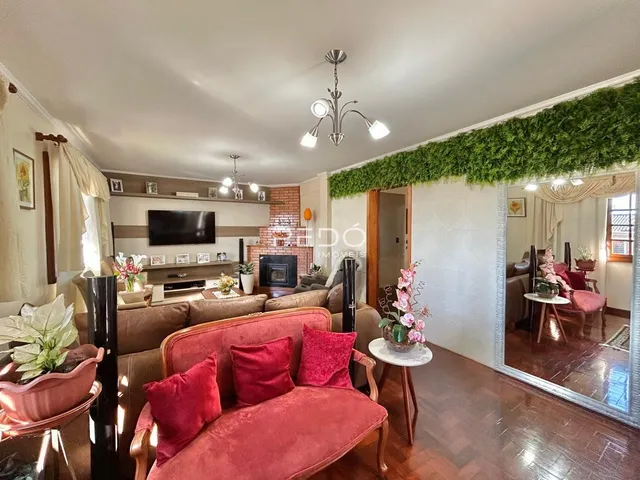Sala de estar com sofá vermelho e lareira em um imóvel no Brasil.