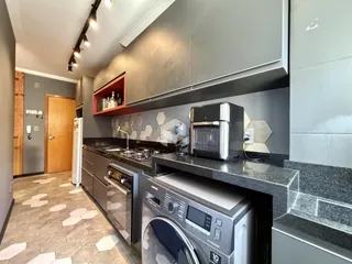 Foto de uma cozinha moderna com armários cinzas e bancadas escuras.