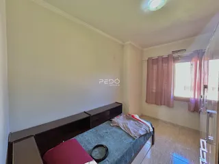 Quarto com cama e janela em imóvel no Brasil.