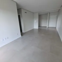Hall de entrada com paredes brancas e piso claro.