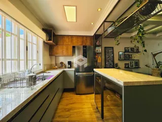 Vista da cozinha moderna com piso de madeira e grandes janelas em Lajeado.