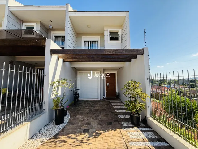 Fachada de uma residência em Lajeado, Brasil com porta de garagem e varanda.