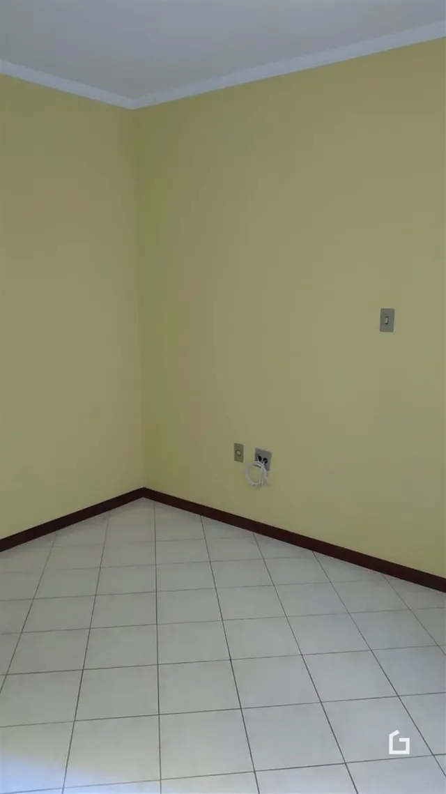 Parede interna de um cômodo com piso de cerâmica.