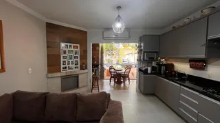 Sala de estar com cozinha integrada e parede de destaque em Lajeado.