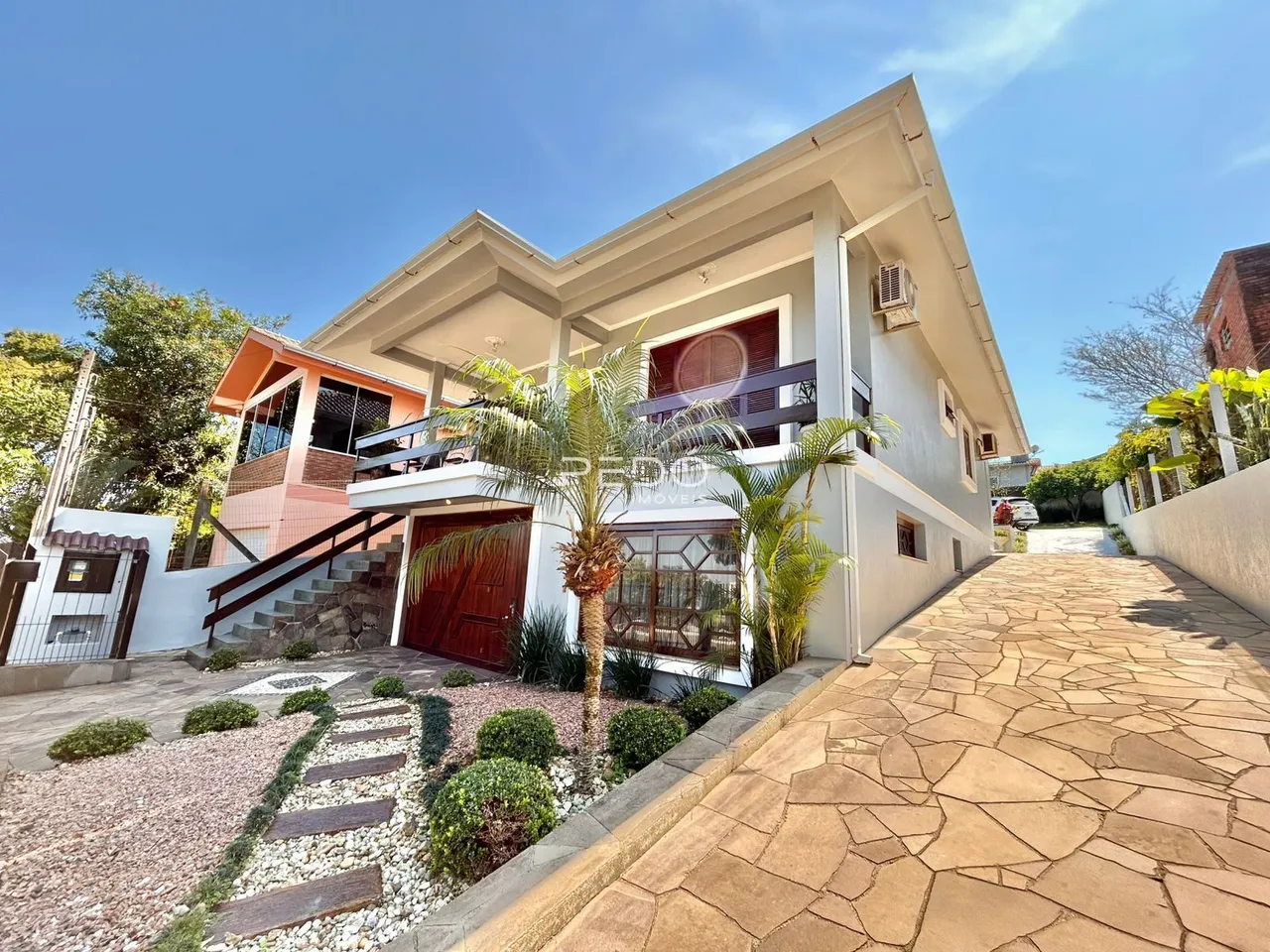 Fachada de uma residência em Lajeado, Brasil, com jardim e calçada.