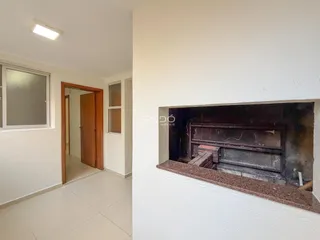 Interior de uma sala com parede branca e porta de madeira em uma residência.