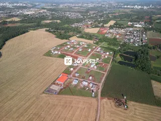 Uma vista aérea de um terreno rural com áreas de cultivo e construções dispersas em Lajeado.