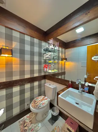 Banheiro com revestimento de azulejos e detalhes em madeira na decoração.