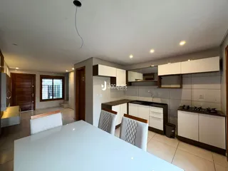 Interior de uma sala de estar com cozinha moderna em Lajeado.