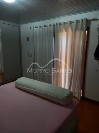 Foto de um quarto com cama e cortinas brancas.