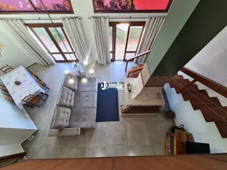 Sala de estar com piso de cerâmica e grandes janelas.