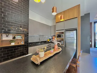 Imagem de uma cozinha moderna com armários cinzas e detalhes em madeira.