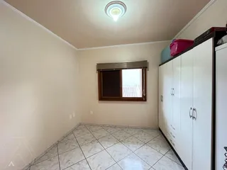 Foto de um corredor interno com piso de porcelanato claro e armários brancos.