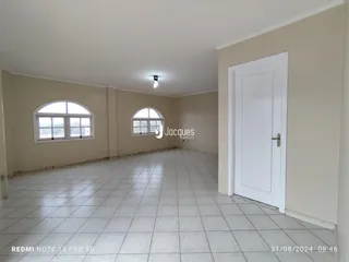 Ambiente interno de uma sala com piso de cerâmica e paredes claras.