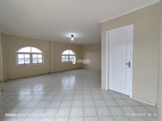 Ambiente interno de uma sala com piso de cerâmica e paredes claras.