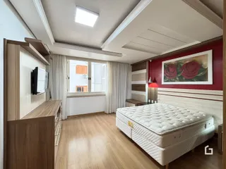 Quarto com cama grande e decoração moderna em ambiente interno.