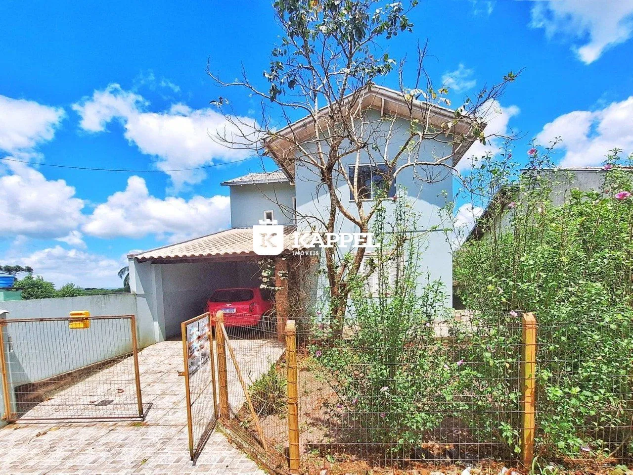 Vista externa de uma casa em Lajeado, Brasil, com cerca e vegetação ao redor.