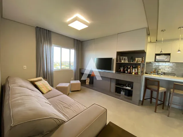 Sala de estar moderna com sofá e janelas em um imóvel no Brasil.