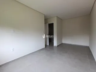 Ambiente interno com paredes brancas e piso de cerâmica.
