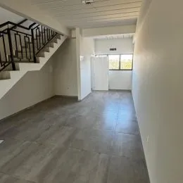 Hall de entrada com escadaria e piso de concreto.