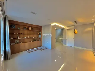 Sala de estar com painel de madeira e piso claro.