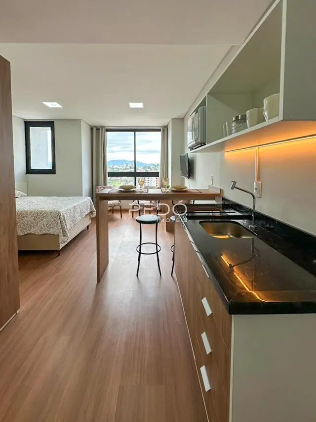 Quarto com vista para a cidade e área de cozinha integrada.