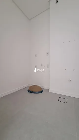 Ambiente interno de um cômodo vazio com paredes brancas e piso claro.