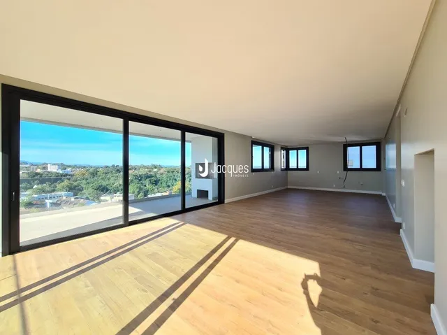 Sala de estar com piso de madeira e porta de vidro que oferece vista para a paisagem.